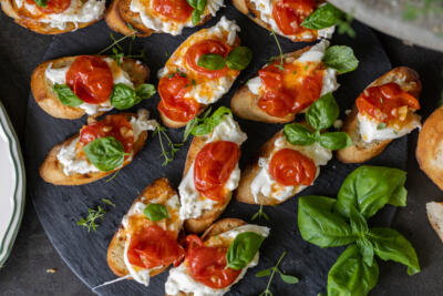 Burrata Crostini with Blistered Tomatoes on a tray.