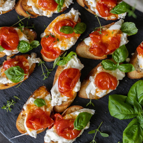Burrata Crostini with Blistered Tomatoes on a tray.