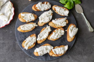 Toasted bread with burrata on a tray.