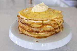 Crepes and cream on a cake stand.