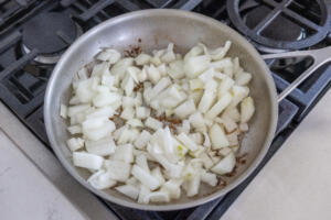 Onions getting cooked in a pan.