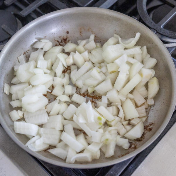 Onions getting cooked in a pan.