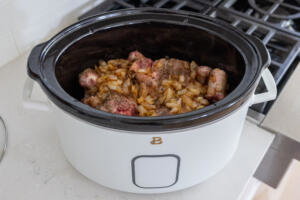 Oxtail and onion in a slow cooker with seasoning.