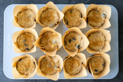 Muffins topped with corse sugar in a pan.