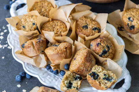 Plate with Banana Blueberry Oat Muffins, a few broken apart.