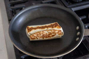 Burrito getting browned in a pan.