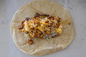 Tortilla with all the burrito ingredients .