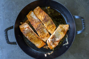 Salmon browned in a pan.