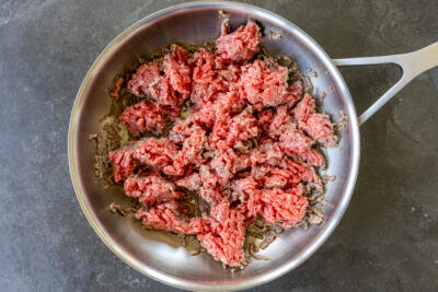 Ground beef cooking in a pan.