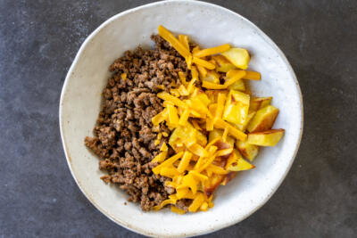 Potato, meat, cheese in a bowl.