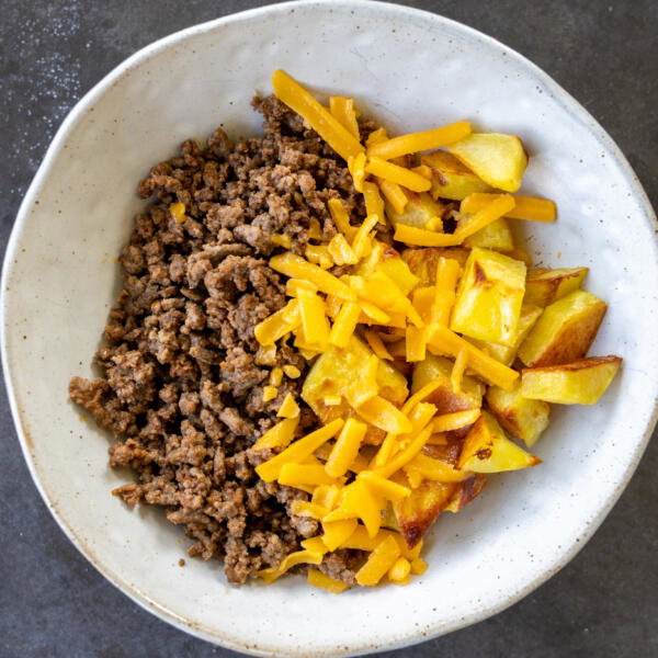 Potato, meat, cheese in a bowl.