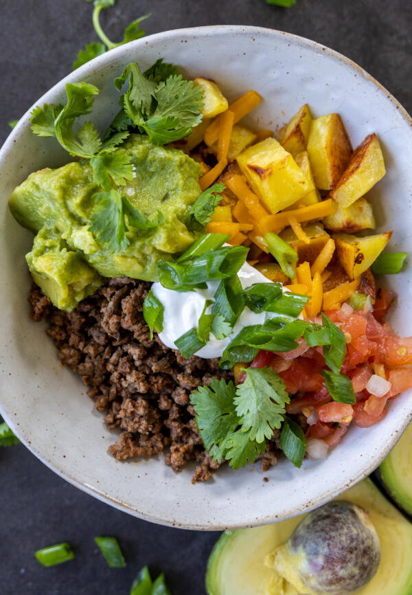 Loaded Potato Taco Bowl with herbs and toppings.