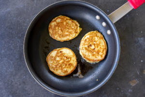 Sourdough Cottage Cheese Pancakes browing on a pan.