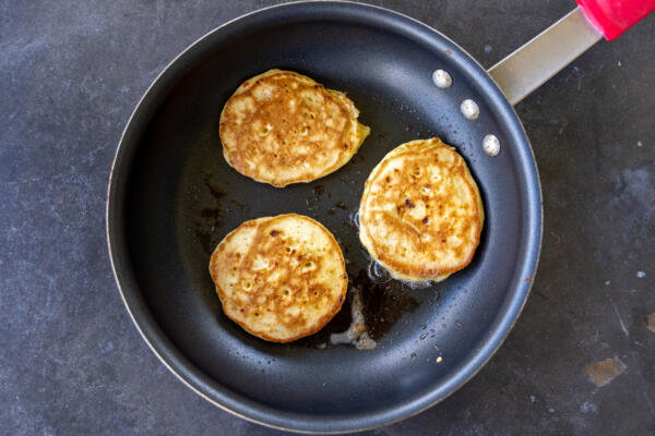 Sourdough Cottage Cheese Pancakes browing on a pan.