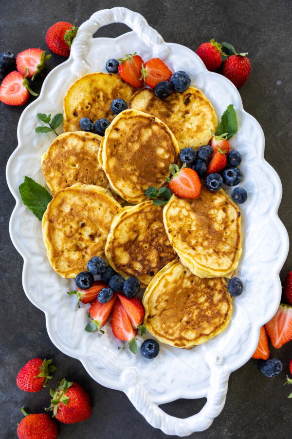 Sourdough Cottage Cheese Pancakes on a tray with berries.